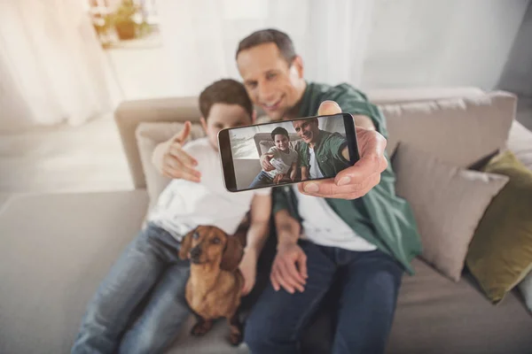 Alegre familia tomando fotos en la cámara del teléfono — Foto de Stock