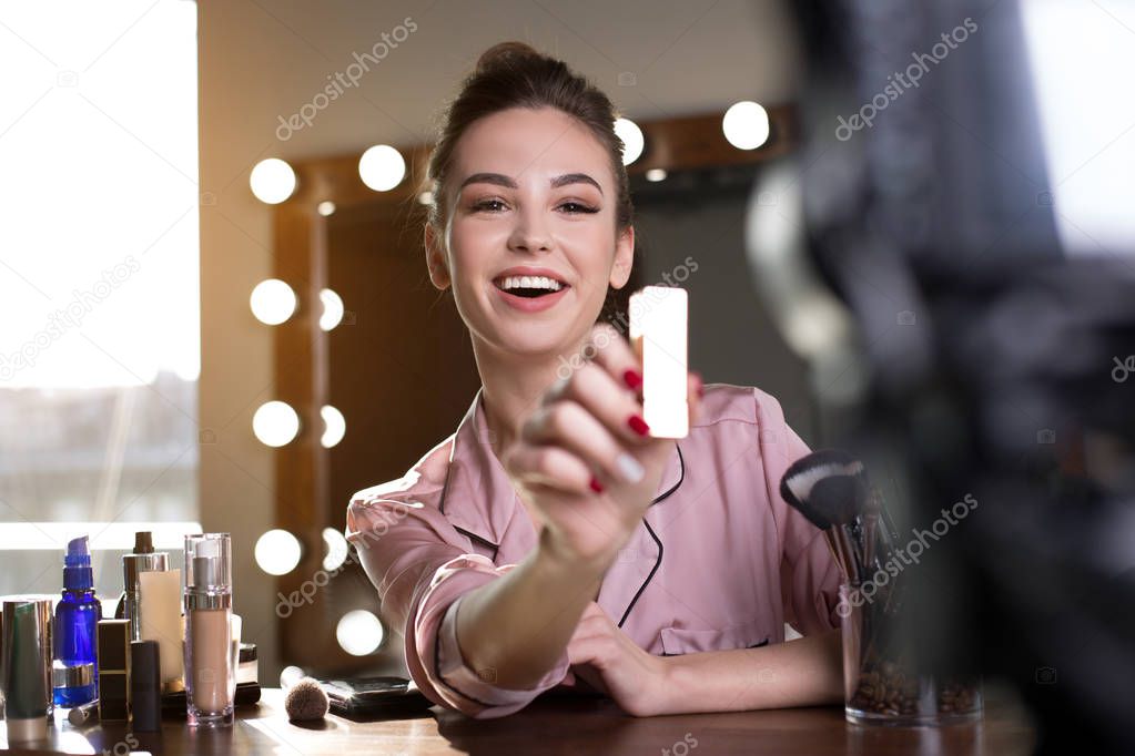 Young woman is filming make up review for her followers