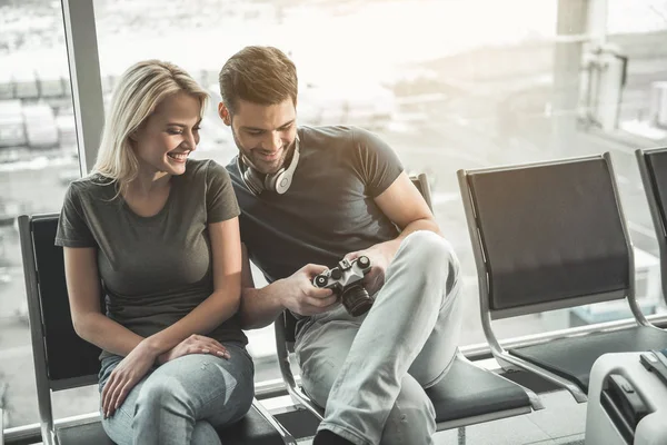 Pareja agradable utilizando el dispositivo digital en el aeropuerto —  Fotos de Stock