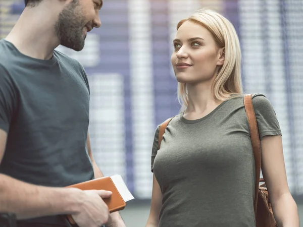 Beaming woman speaking with glad man in airport — Stock Photo, Image