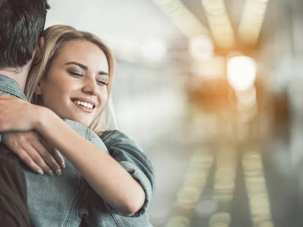 Beaming feminino abraçando o homem dentro — Fotografia de Stock