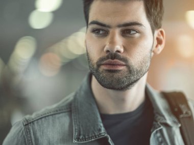 Dalgınlık gösteren tıraşsız genç erkek