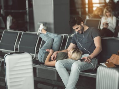 Gülümseyen kadın havaalanında memnun erkek ile konuşurken