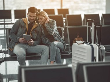 Memnun kız ve adam salonda tablet kullanma