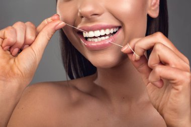 Genç kadın zevk ile dişlerini diş ipi