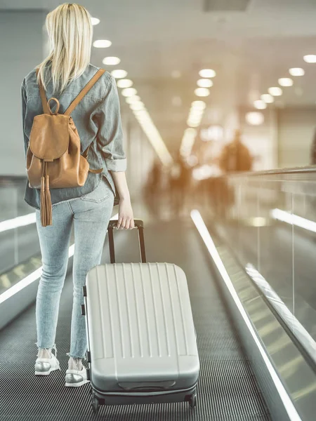 Dziewczyna, zachowując duże walizki na ruchomych schodach — Zdjęcie stockowe