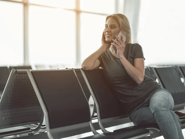 Wesoła kobieta rozmawia przez telefon komórkowy w Lotnisko — Zdjęcie stockowe