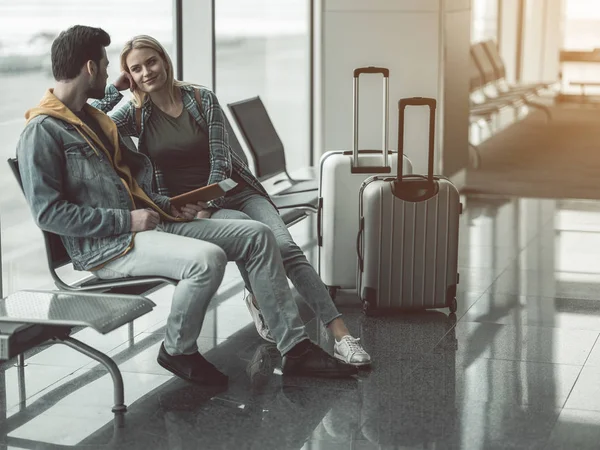 Glad female speaking with man in airport — Stock Photo, Image