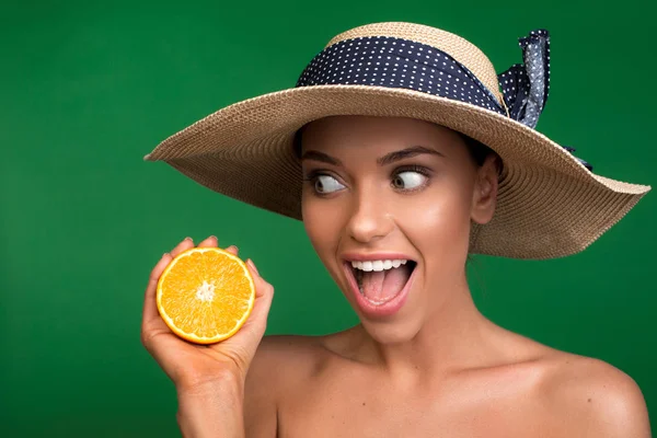 Girl in headdress demonstrating delicious orange — Stock Photo, Image