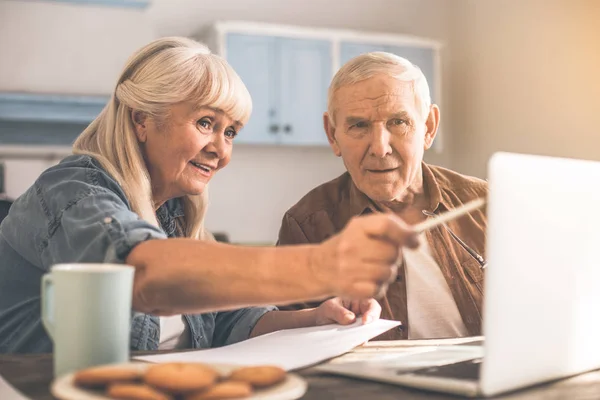 Épouse et mari séniors excités utilisant un ordinateur portable dans la cuisine — Photo