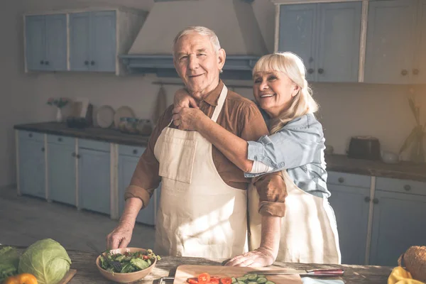 Esposa feliz abrazando a su marido en la sala de cocina — Foto de Stock