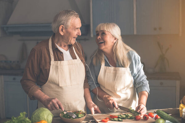 Excited mature pensioners preparing dinner together