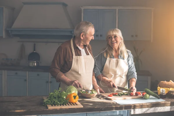 Cheerful senior husband and wife cooking with music — Stock Photo, Image