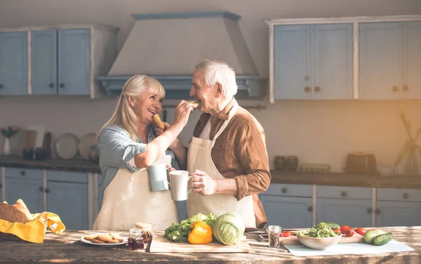 Glücklich reife Mann und Frau essen leckere Brötchen mit Tee — Stockfoto