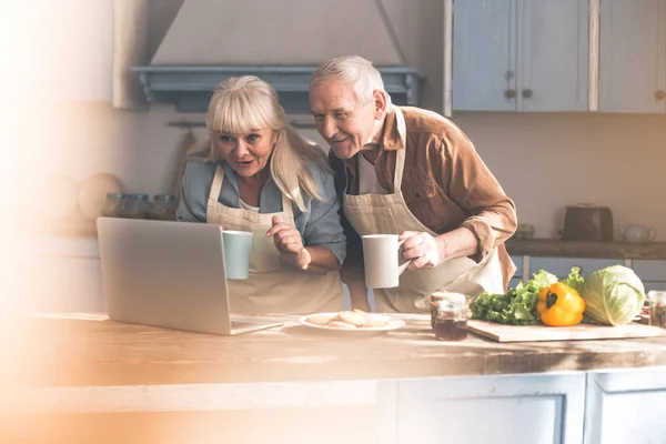 Opgewonden volwassen man en vrouw lezen recept op computer — Stockfoto