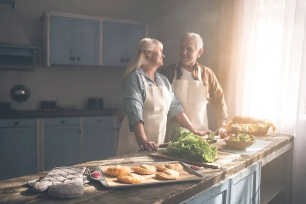 Gelukkig oud getrouwd koppel bakken broodjes in keuken — Stockfoto