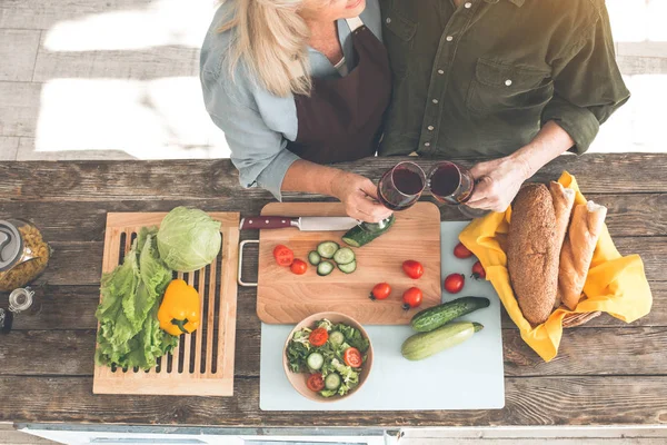 Gelukkig oude man en de vrouw het drinken van wijn in de keuken — Stockfoto