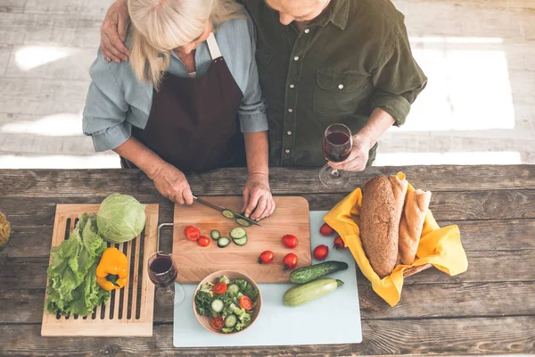 Feliz pareja de ancianos preparando el almuerzo en la cocina juntos — Foto de Stock