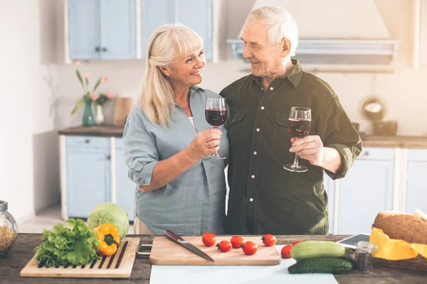 Веселый пожилой мужчина и женщина наслаждаются романтикой в кухне — стоковое фото