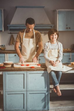 Adam ve çocuk zevk ile tatlı yemek yapıyor