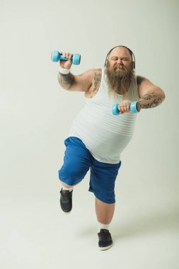 Kulaklıklar ile Halter kaldırma heyecanlı kalın adam