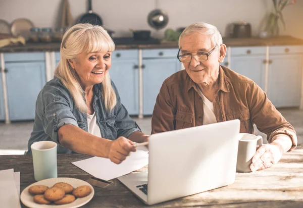 Joyful mogen man och hustru med laptop i köket — Stockfoto