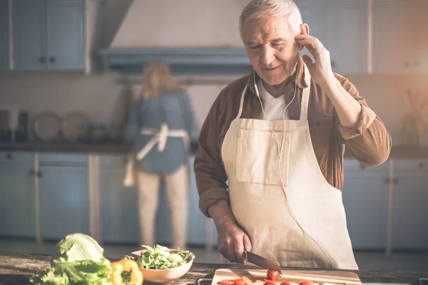 Fröhliche ältere Rentnerin genießt Melodie in Küche — Stockfoto