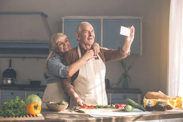 Gelukkig volwassen man en vrouw nemen foto op telefoon — Stockfoto