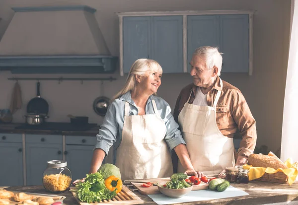 Alegre hombre viejo y mujer preparando la cena en la cocina — Foto de Stock
