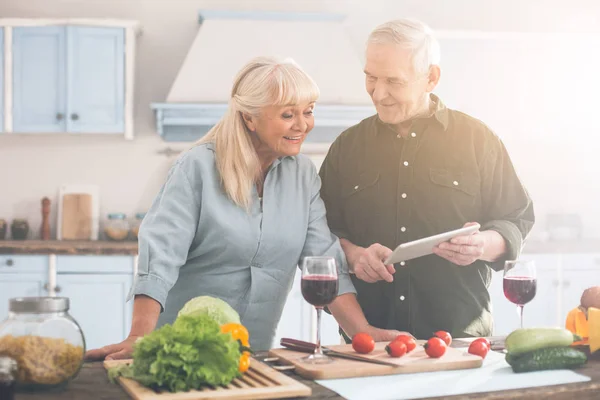 Positivo pareja de ancianos casados decidiendo qué cocinar — Foto de Stock