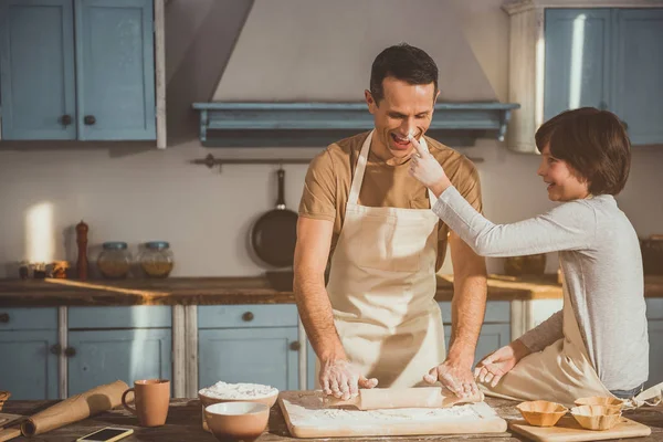 Dad and child entertaining during kneading