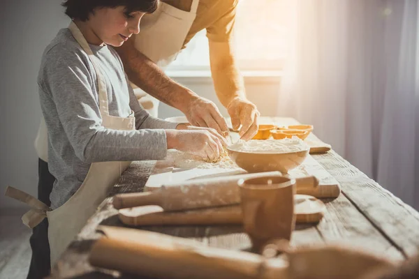 Dad and child combining dough ingredients — Stock Photo, Image