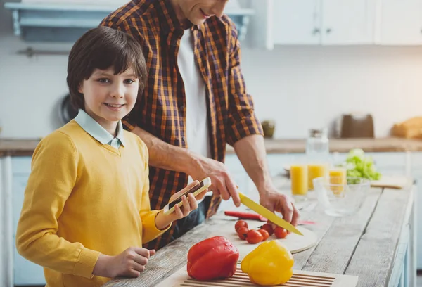 Man and boy cooking according to recipe from internet — Stock Photo, Image