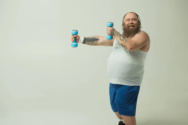 Feliz hombre gordo haciendo ejercicio con pesas — Foto de Stock