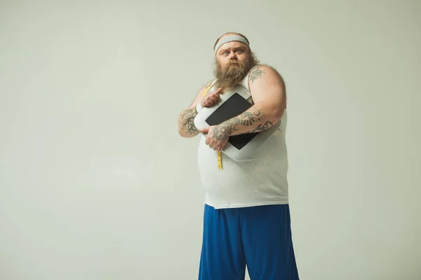 Hombre gordo aturdido manteniendo balanzas después de pesar — Foto de Stock