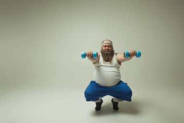 Ağırlıklar ile egzersiz yaparak neşeli kalın adam