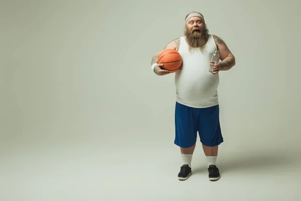 Fatso masculino confiado que repone fluidos corporales después del partido de baloncesto — Foto de Stock