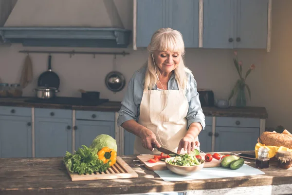Gelukkig senior dame bereiden van gezond voedsel in keuken — Stockfoto