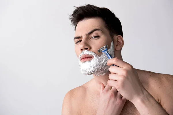 Young man is removing unwanted hair from his face — Stock Photo, Image