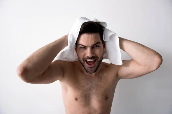 裸の胴体を持つ陽気な直立させた男は、彼の頭を拭いています。 — ストック写真