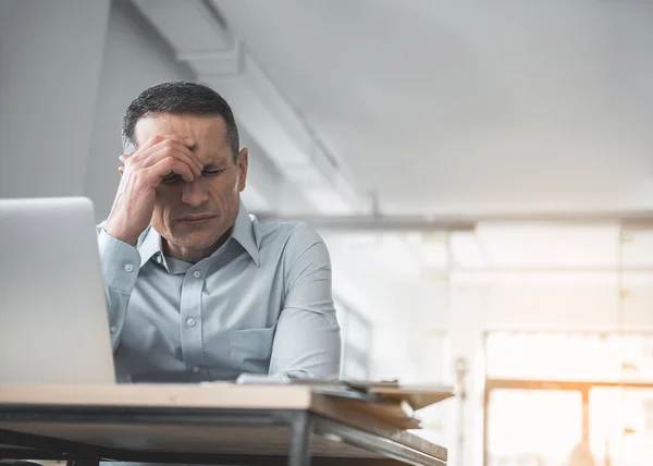 Hombre de negocios preocupado sintiendo dolor de cabeza en el trabajo — Foto de Stock