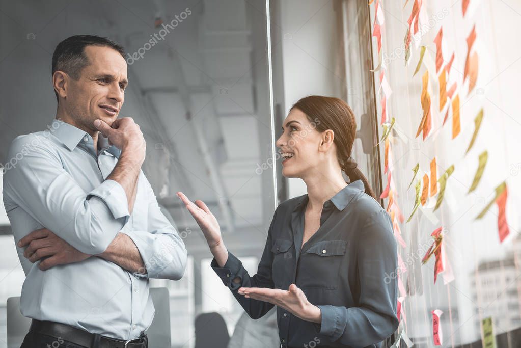 Cheerful partners speaking in office