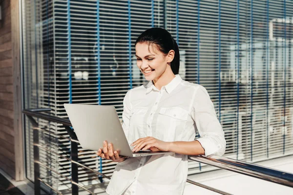 Bilgisayar dışında kullanan neşeli kadın