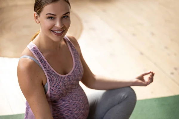Happy young expectant mother on exercise mat — Stok fotoğraf
