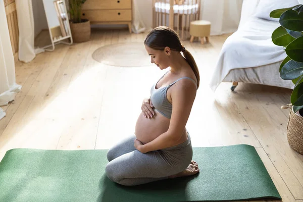 Bastante embarazada madre es relajarse en la habitación —  Fotos de Stock