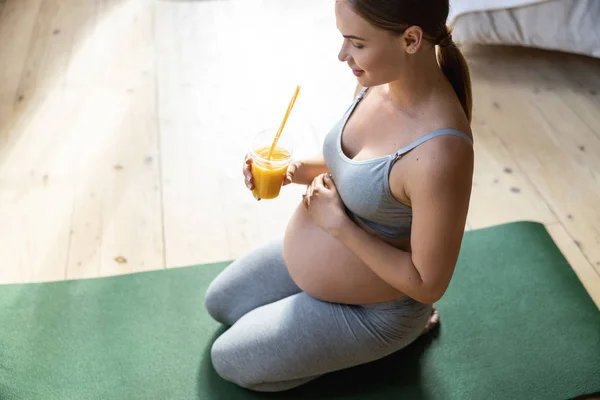 Smiling pregnant woman holding drink in hand — Stock Photo, Image