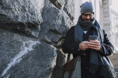 Yetişkin Kafkasyalı bir adam dışarıdan ekrana bakıyor.