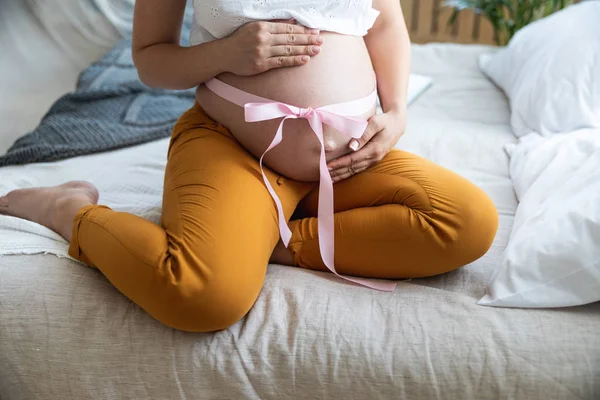 Pregnant woman is holding her stomach affectionately — Stock Photo, Image