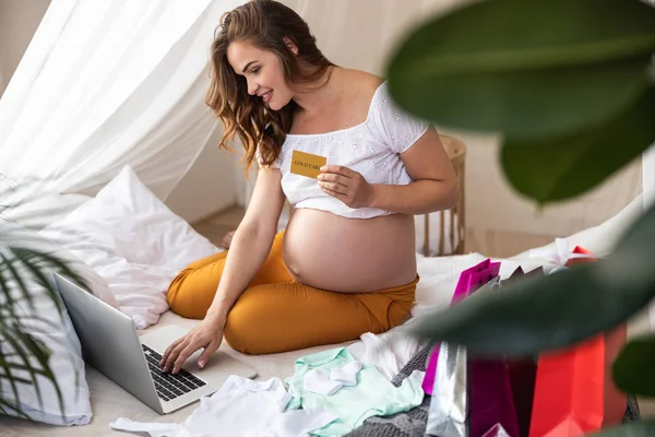 Улыбающаяся молодая беременная женщина делает заказ в интернете — стоковое фото
