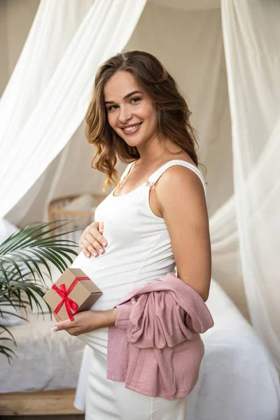 Щаслива красива вагітна жінка, що стоїть в її будинку — стокове фото